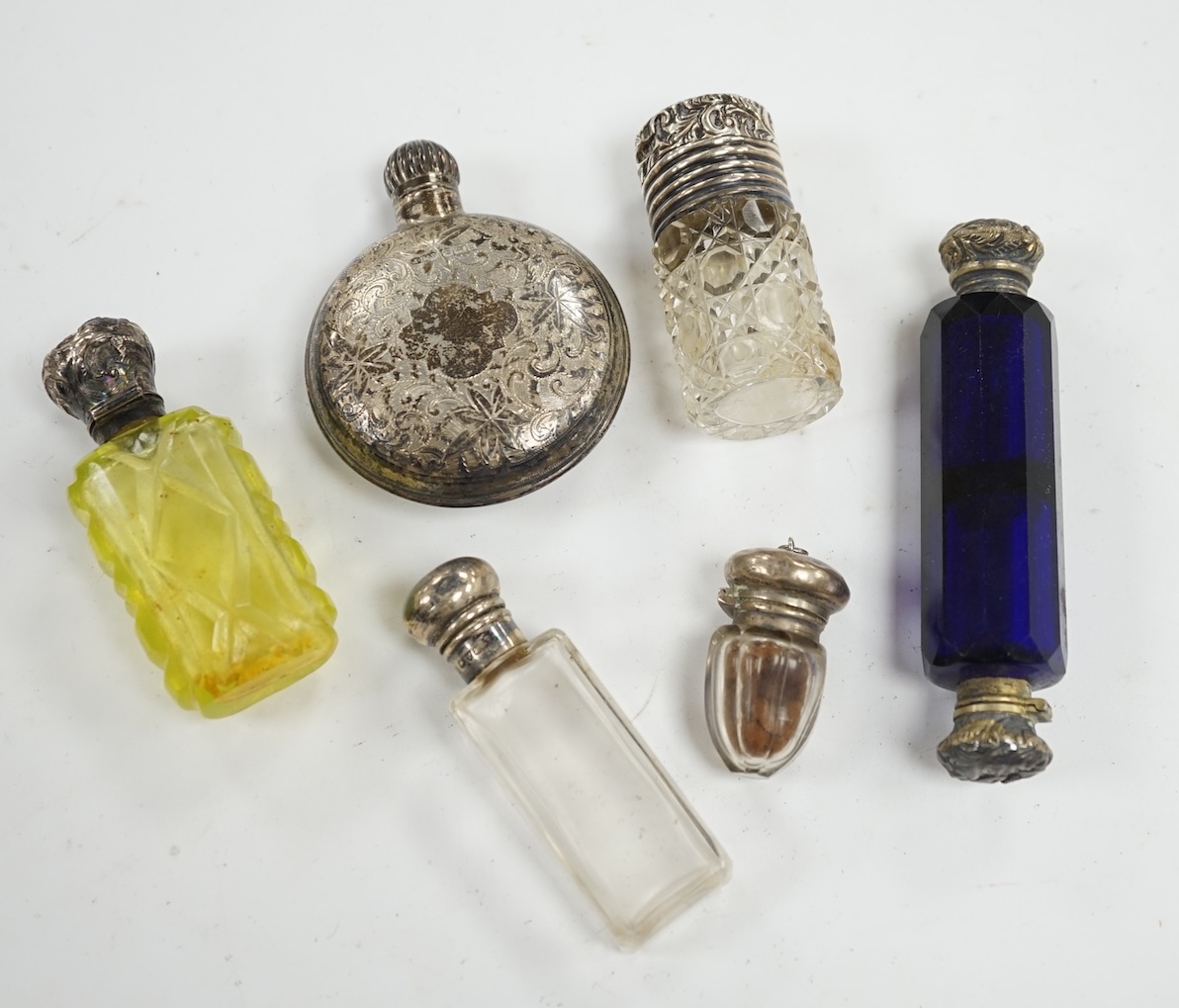 A George V engraved silver moon shaped scent bottle, James Dixon & Sons, Sheffield, 1912, together with five other white metal mounted glass scent bottles. Condition - poor to fair